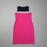 Pink dress and black item on a tiled floor